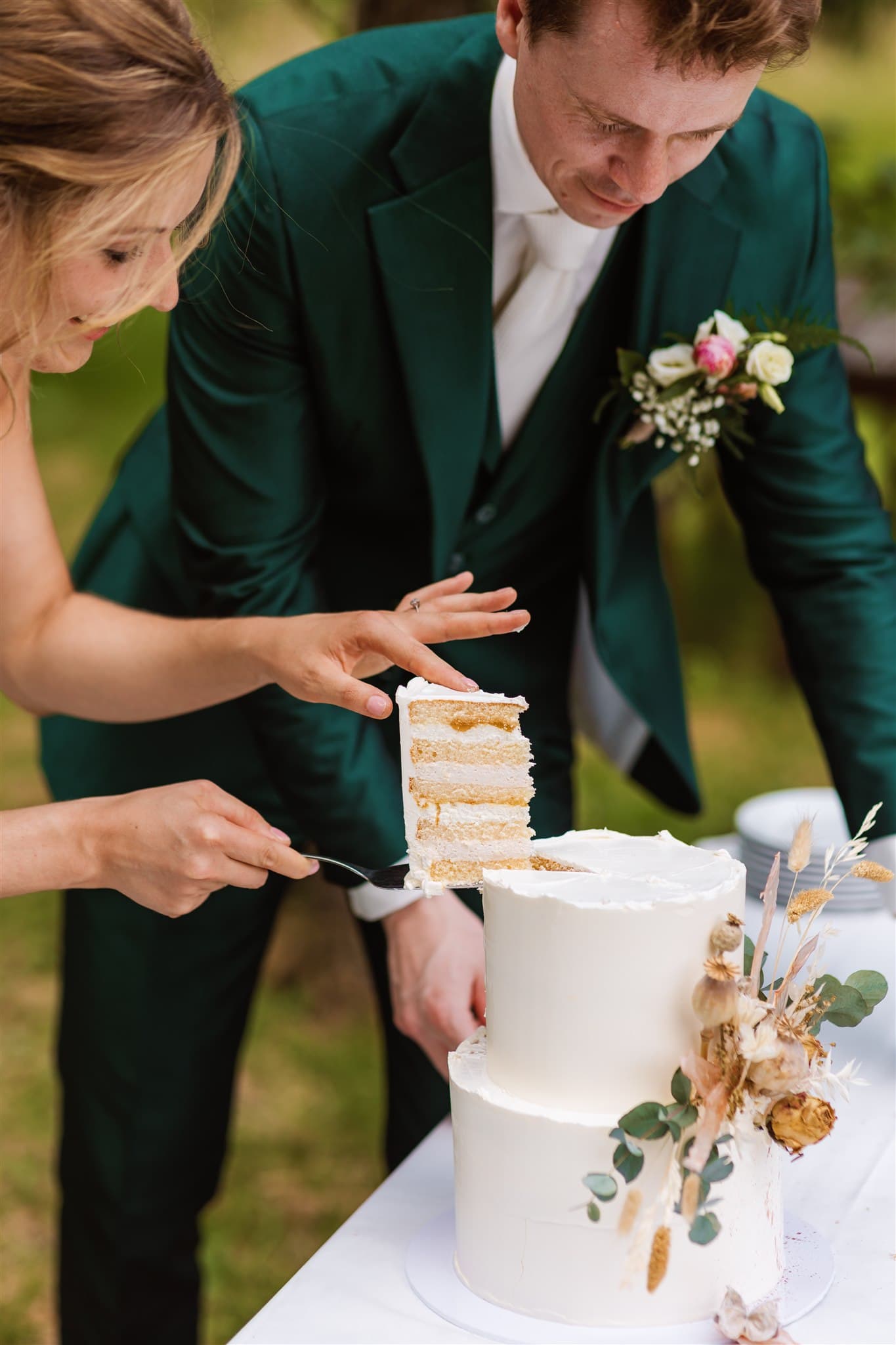 Een foto gemaakt door een trouwfotograaf uit Drenthe van een stukje bruidstaart dat door de bruid uit de taart wordt geschept.