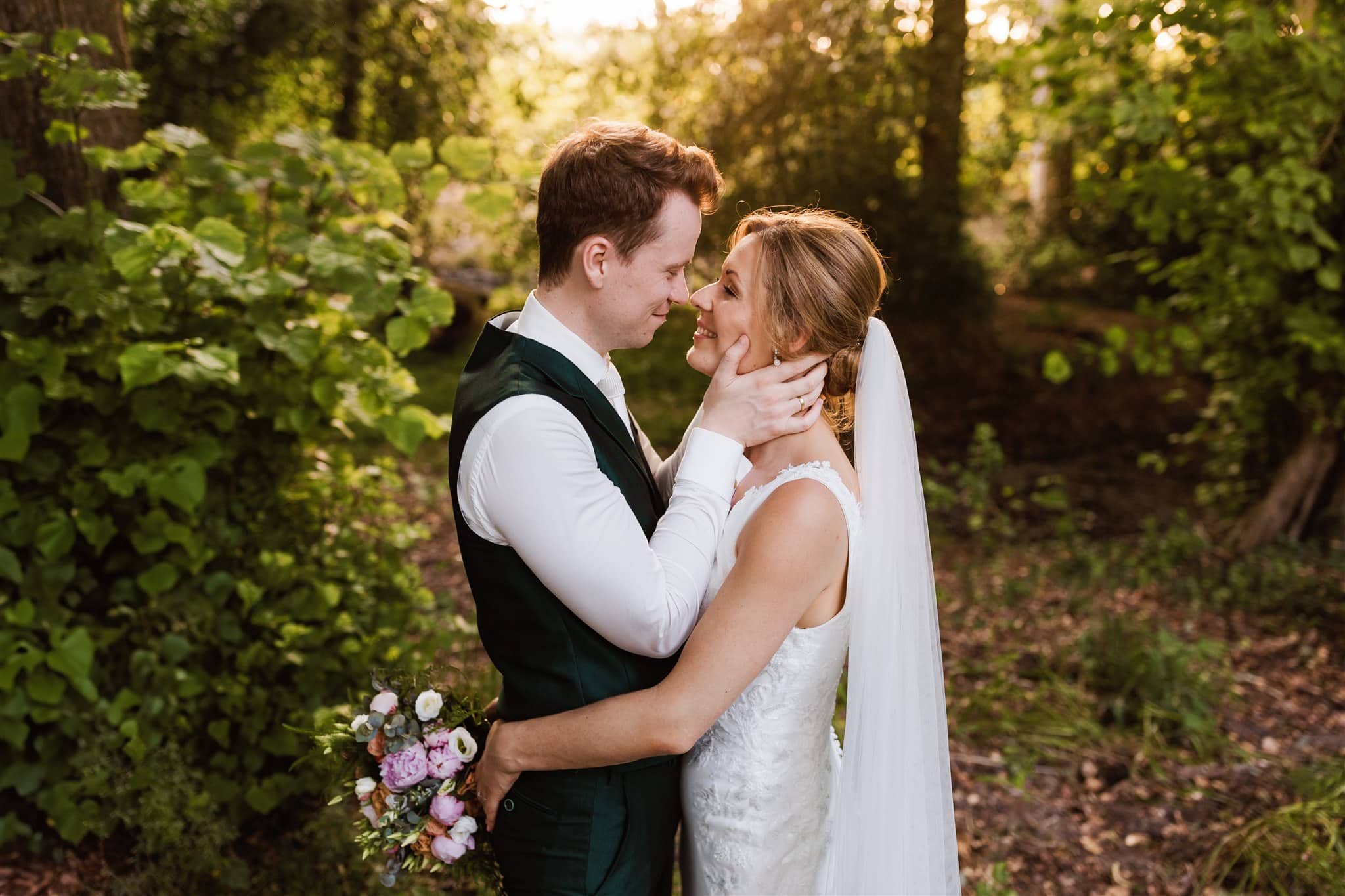 Bruidspaar omhelst elkaar liefdevol bij Landgoed Lemferdinge op een trouwfoto van een trouwfotograaf uit drenthe.