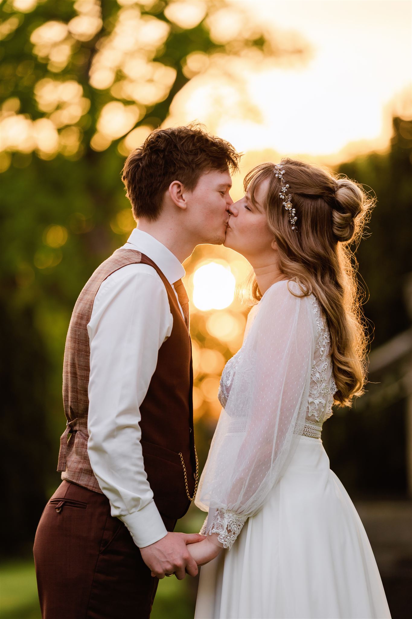 Bruidspaar kust elkaar tijdens hun fotoshoot met zonsondergang op hun bruiloft bij Borg Nienoord