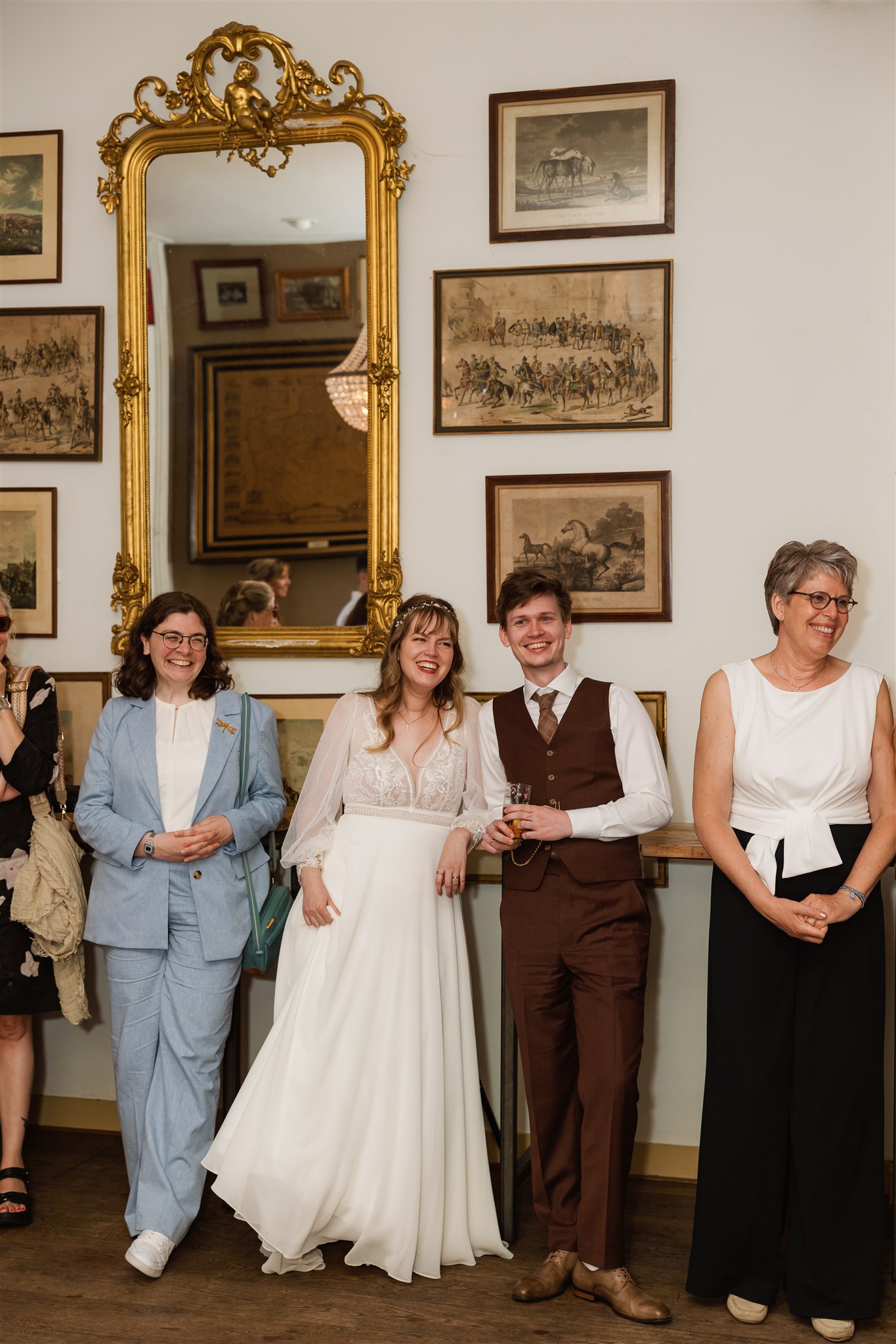 Bruidspaar staat lachend in de balzaal van Borg Nienoord tijdens een speech op hun trouwfeest