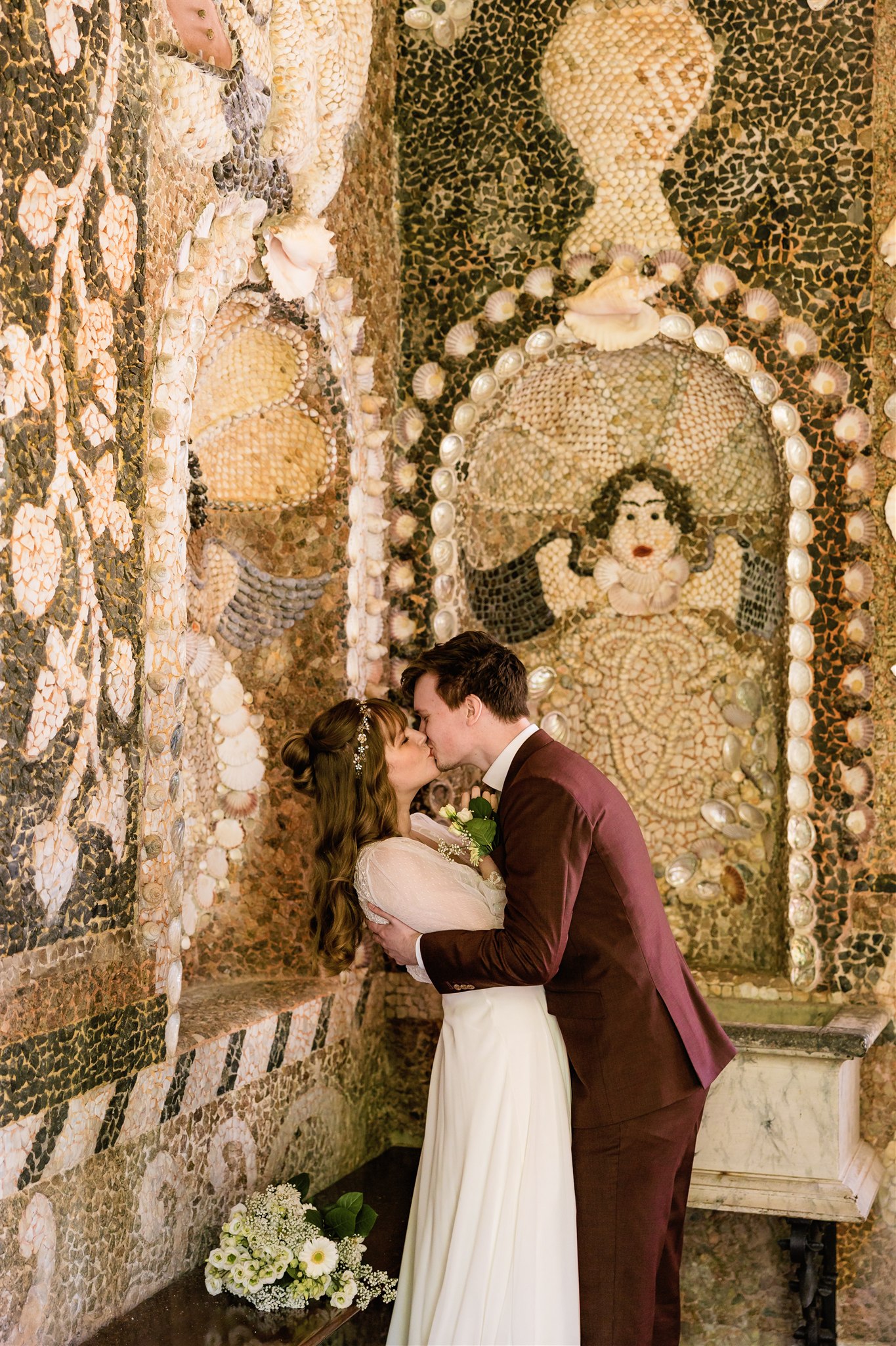 Trouwfoto van een bruidspaar dat elkaar kust in de Schelpengrot van Borg Nienoord