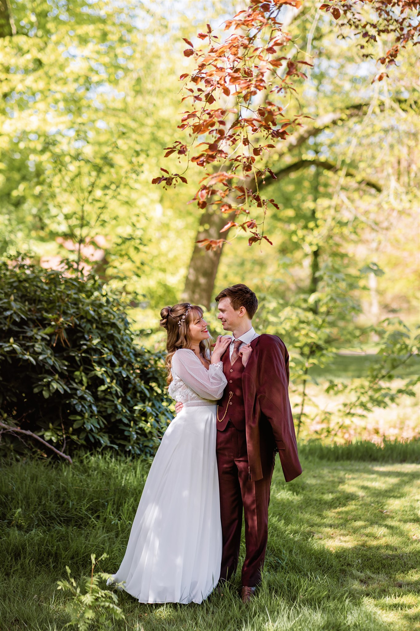 Een bruid leunt lachend op de schouder van haar bruidegom tijdens de fotoshoot op hun trouwdag.
