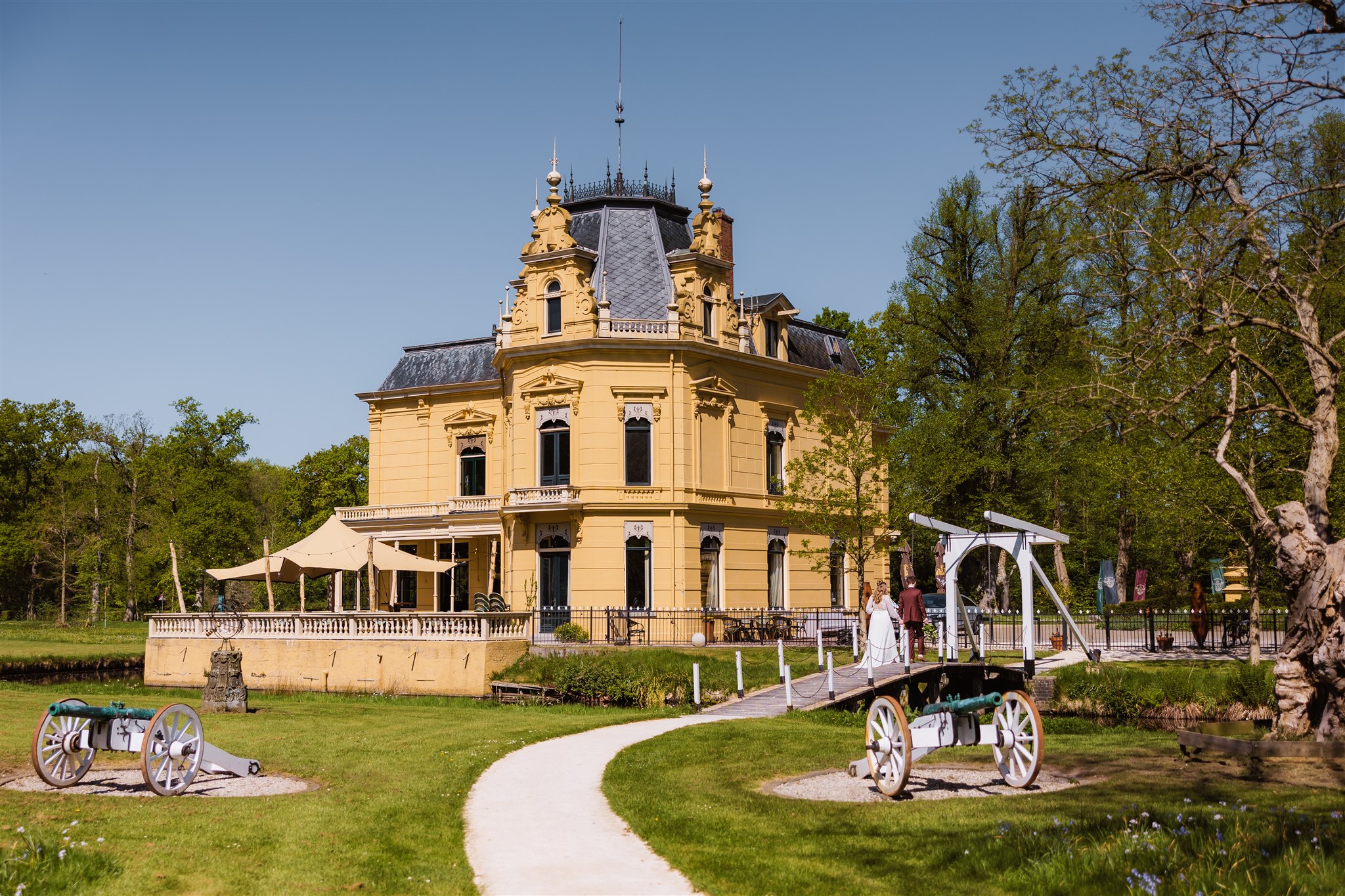 Bruidspaar loopt door de tuin van de trouwlocatie Borg Nienoord in Leek, Groningen