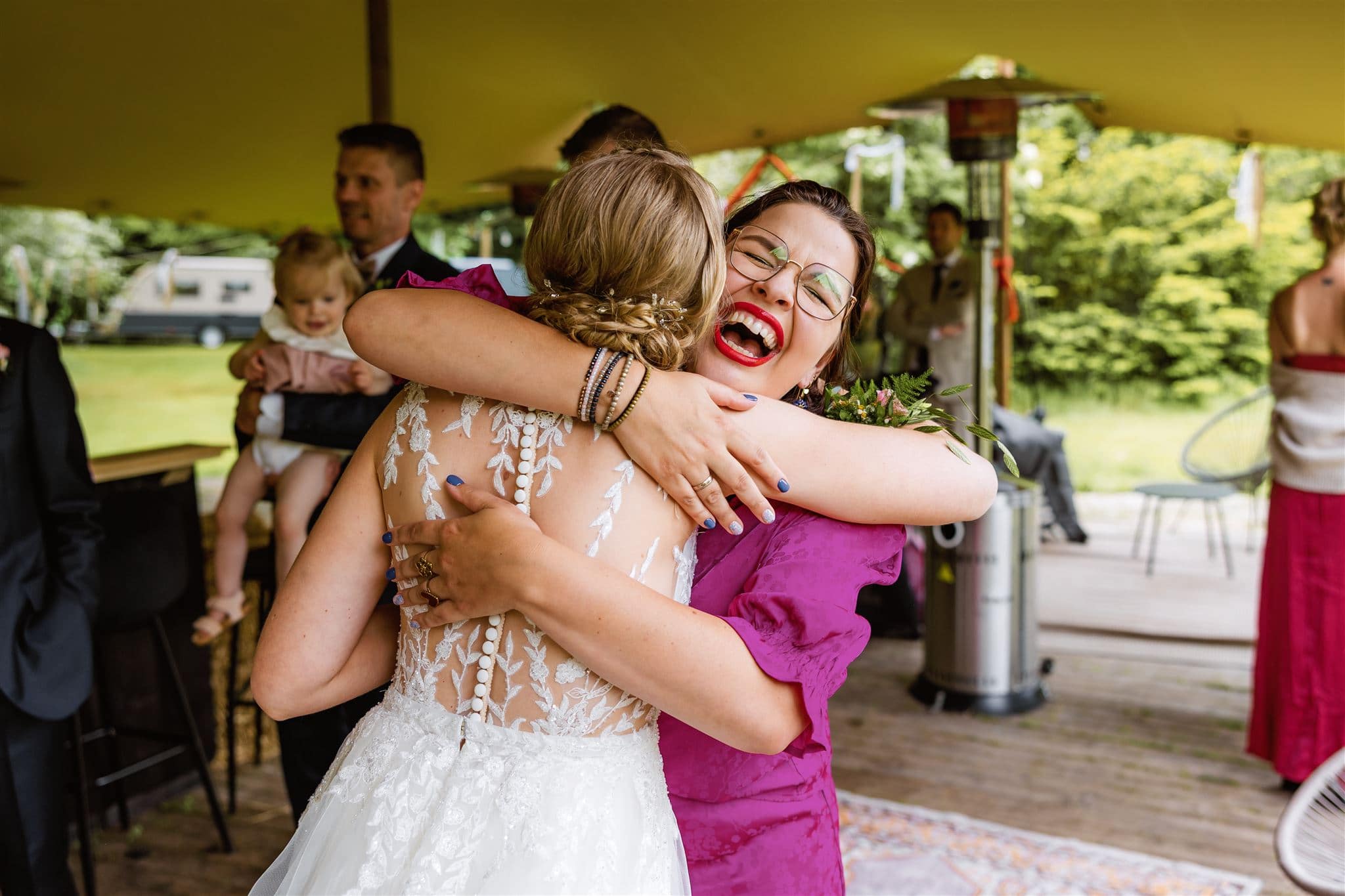 Vriendin geeft de bruid een knuffel tijdens de trouwreceptie bij het Bovenveen in Echten.