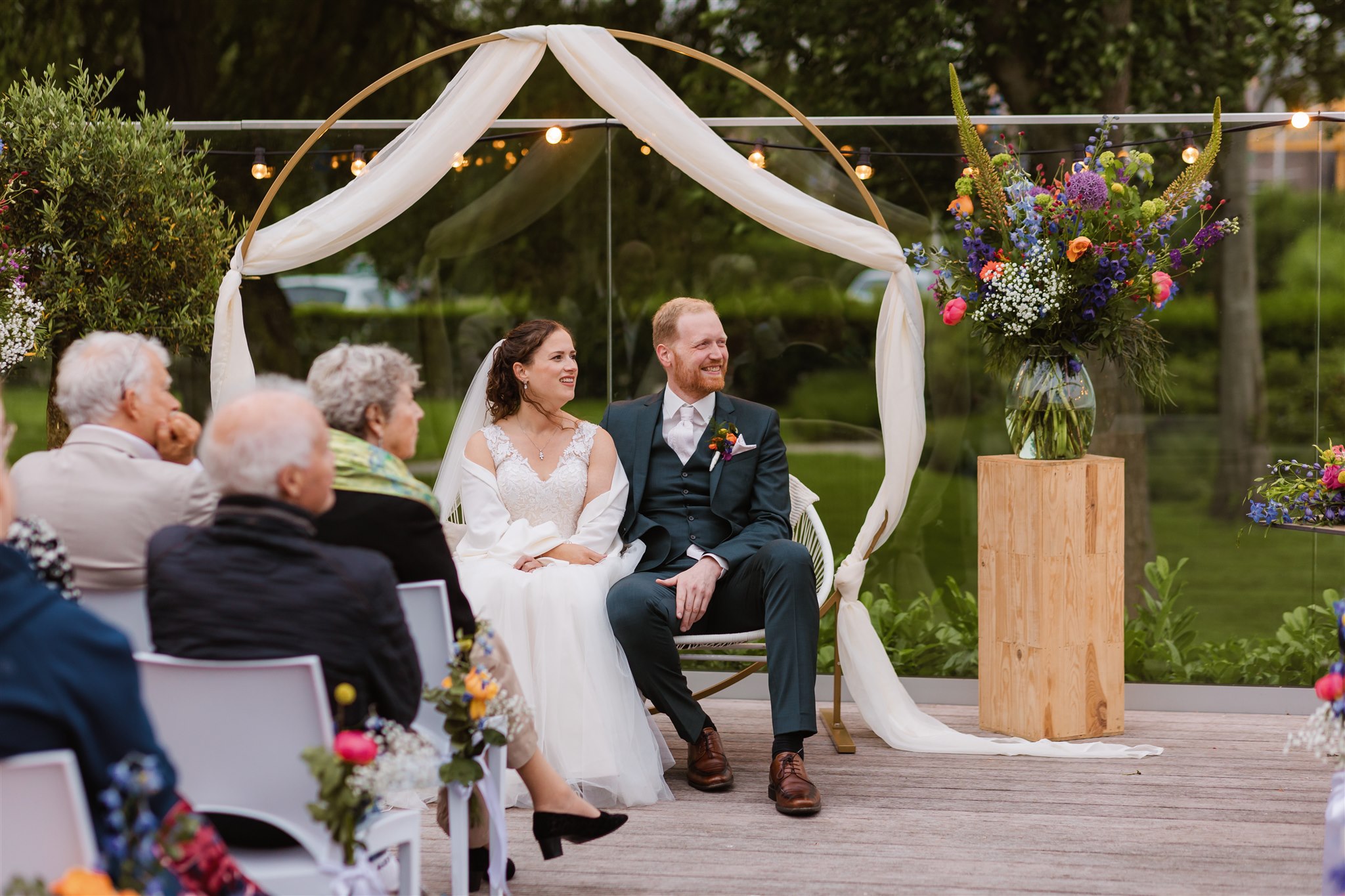 Bruidspaar tijdens avondceremonie op het zijterras van de Paalkoepel aan het water