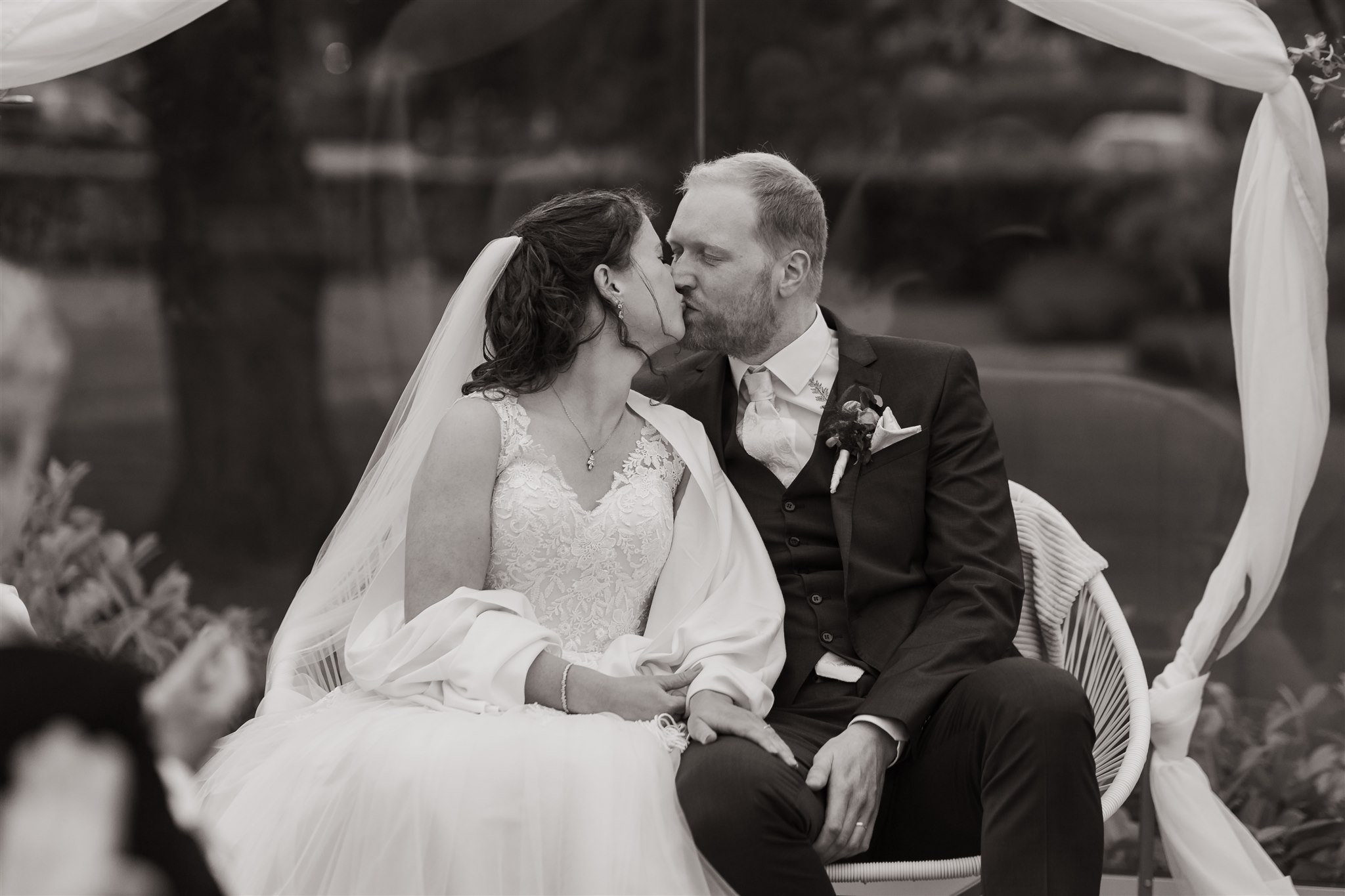 Trouwfoto van een bruidspaar dat elkaar kust tijdens hun ceremonie bij de Paalkoepel