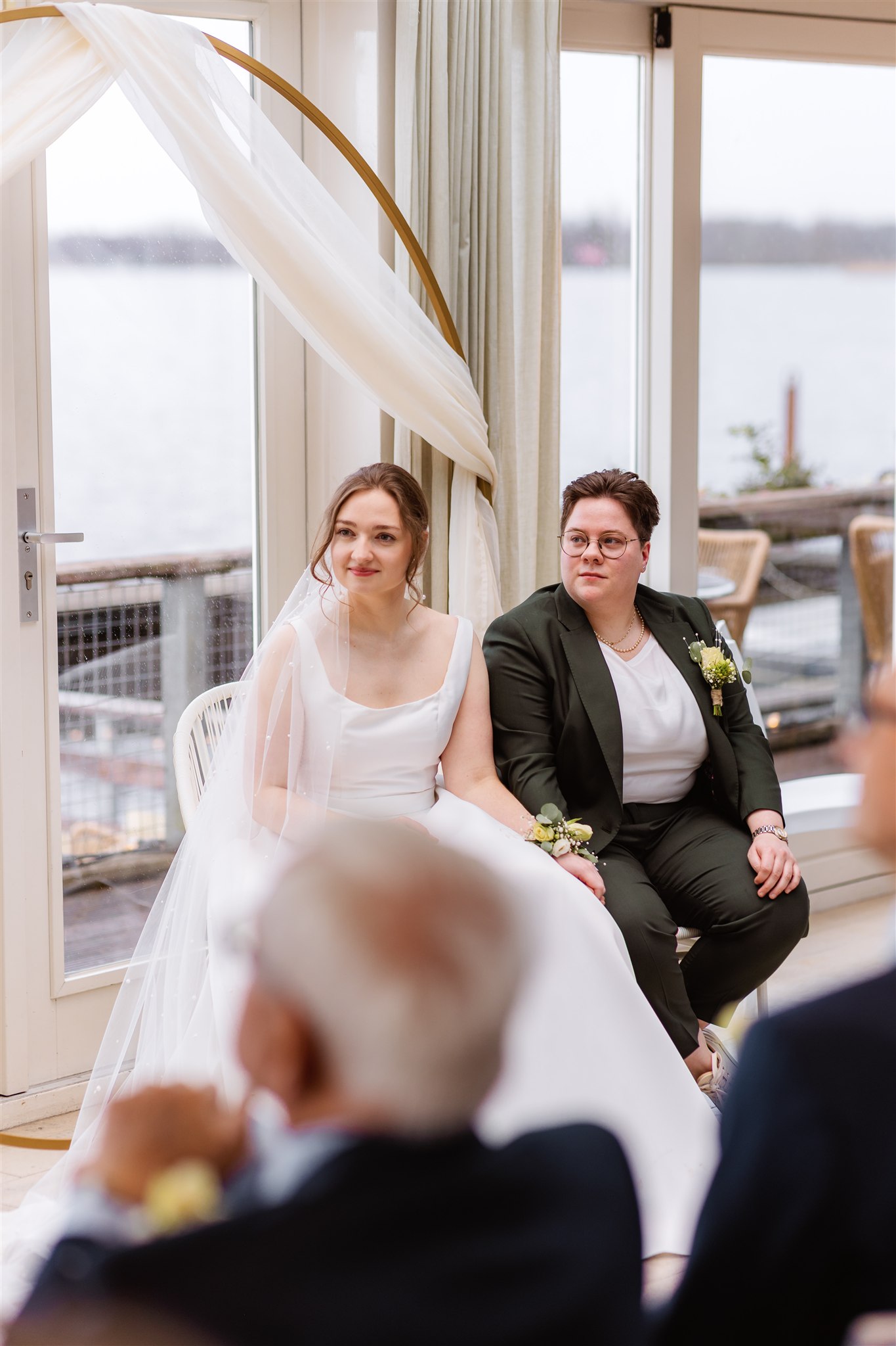 Lesbisch bruidspaar luistert naar de BABS tijdens hun winterbruiloft bij de Paalkoepel