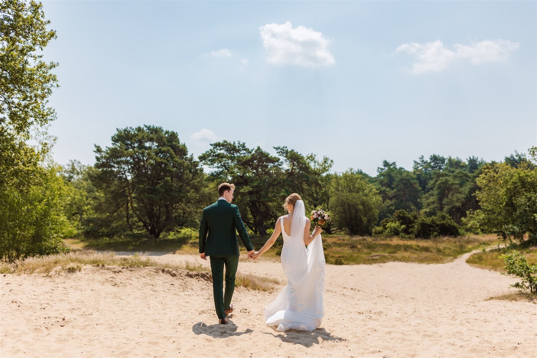 Trouwfoto van een bruidspaar in het zand van de Zeegserduinen