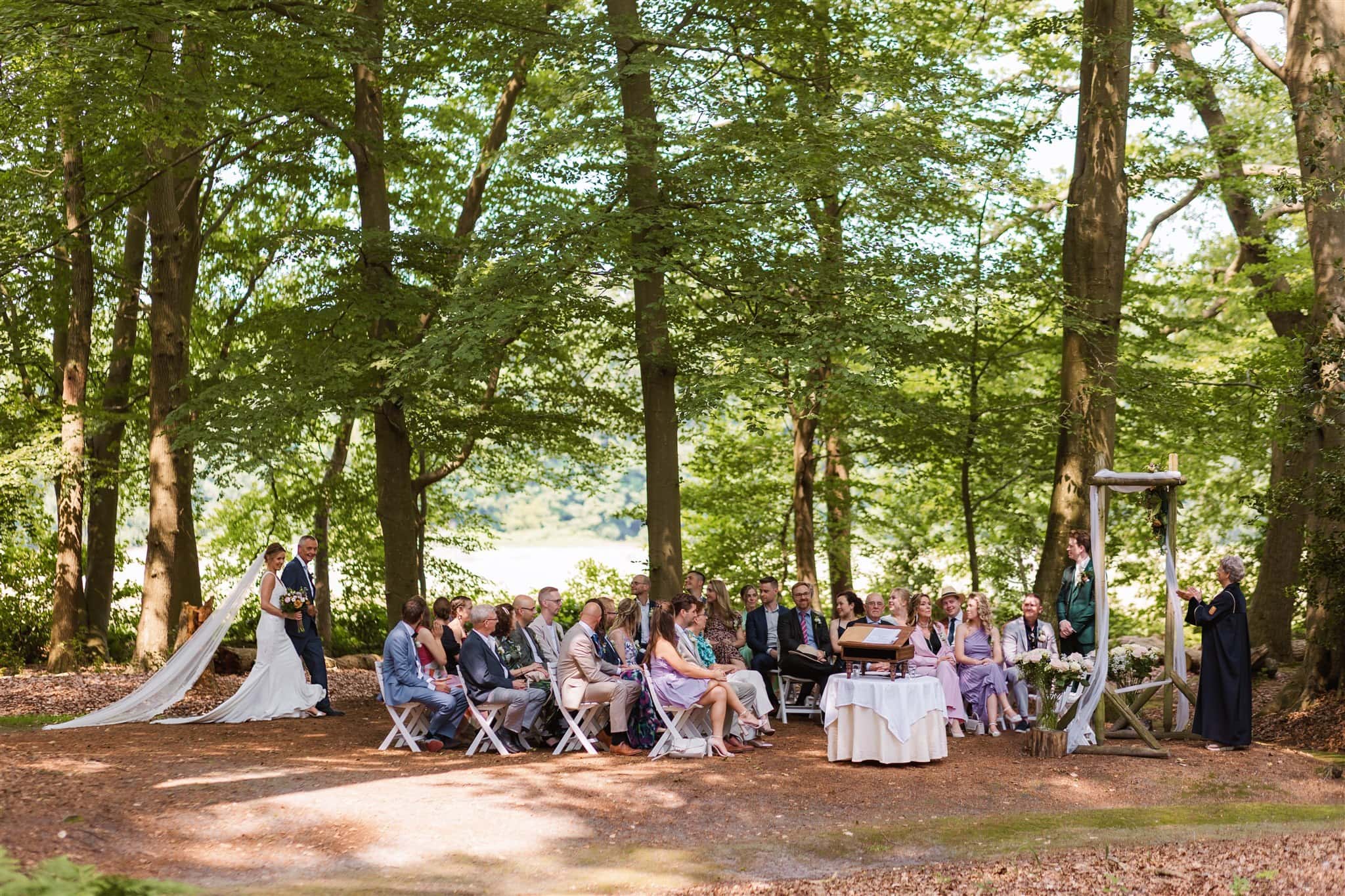 Bruidspaar trouwt tijdens een ceremonie in het bos van Landgoed Lemferdinge